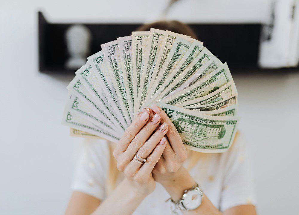 A person holding money in front of their face.